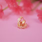 Gold ring with floral design on a pink background