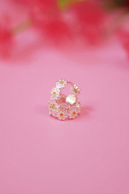 Decorative ring with floral design on a pink background
