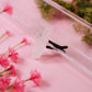 Close-up of a crystal car vent clip with pink flowers and green leaves on a pink background