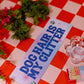 Sign with 'Dog hair is my glitter' on a red and white checkered tablecloth.
