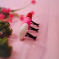 Pink red and white felt heart car vent clips on pink background with greenery in the background