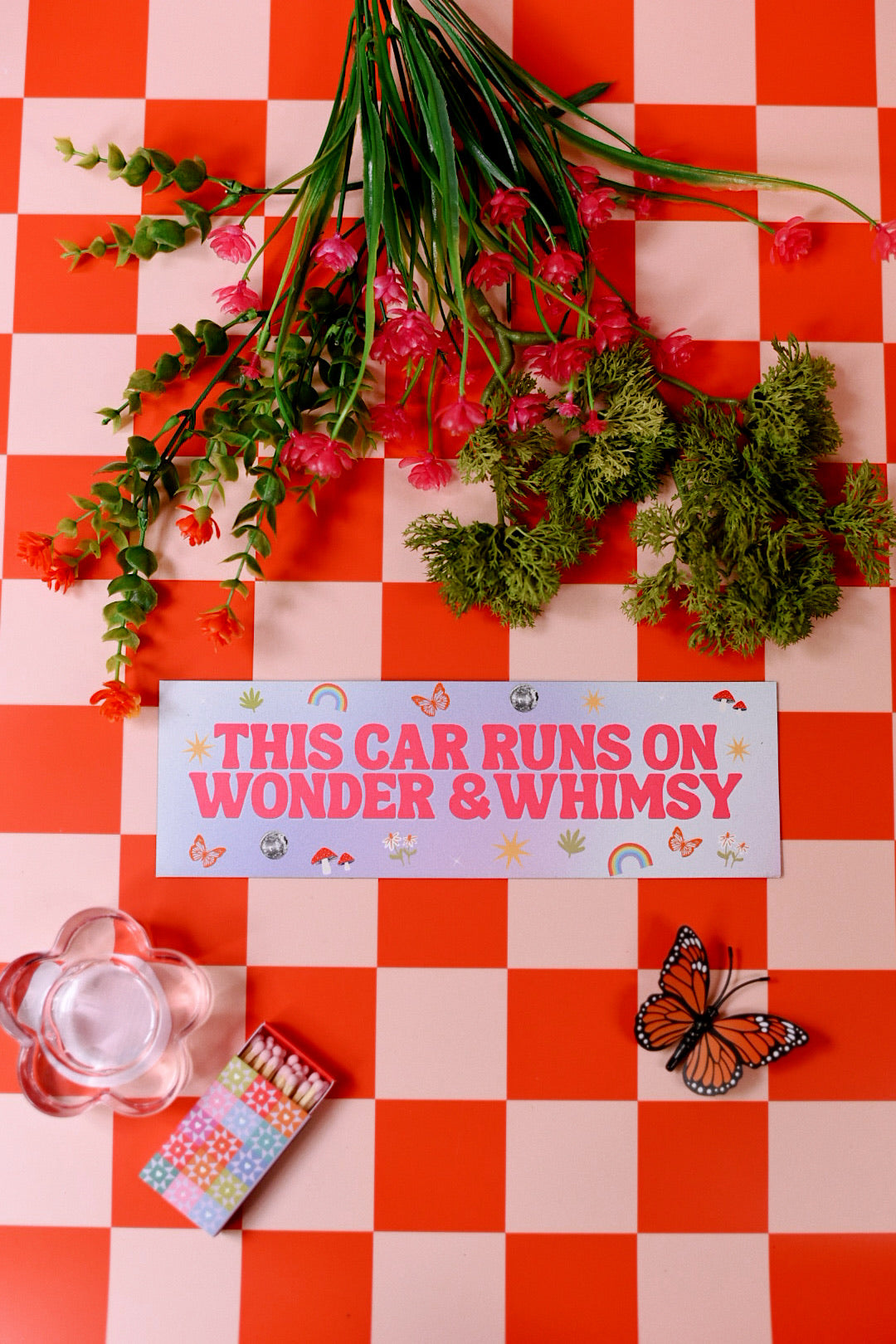 Decorative sign with flowers and butterfly on a red and white checkered background