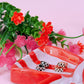 Set of rings on a red and white dish with flowers in the background