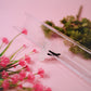 Close-up of a crystal car vent clip with pink flowers and green leaves on a pink background