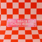 Pink license plate with 'WILL BRAKE FOR HUMAN RIGHTS' text on a red and pink checkered background