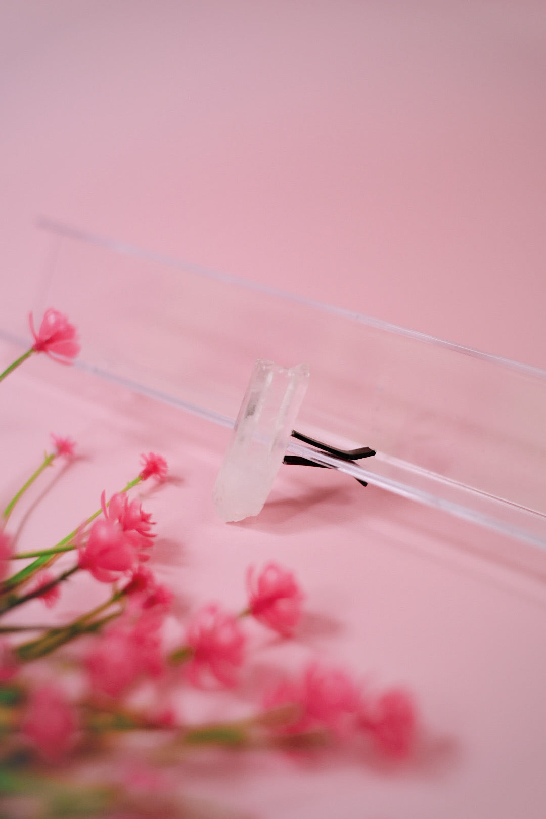 Close-up of a crystal car vent clip with pink flowers on a pink background