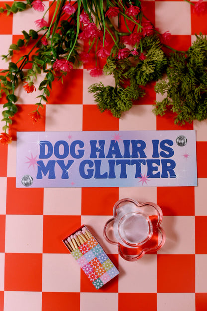 Decorative sign with 'Dog Hair is My Glitter' on a red and white checkered background with flowers and matches.